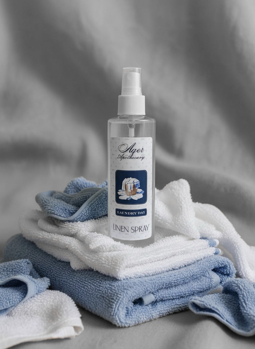 Linen spray bottle on a stack of folded blue and white towels against a gray background